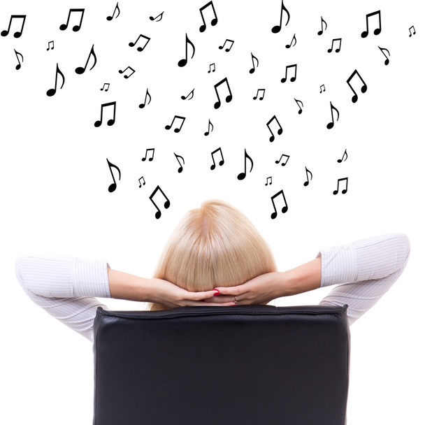 back view of woman sitting on office chair and listening music o - Photo, Image