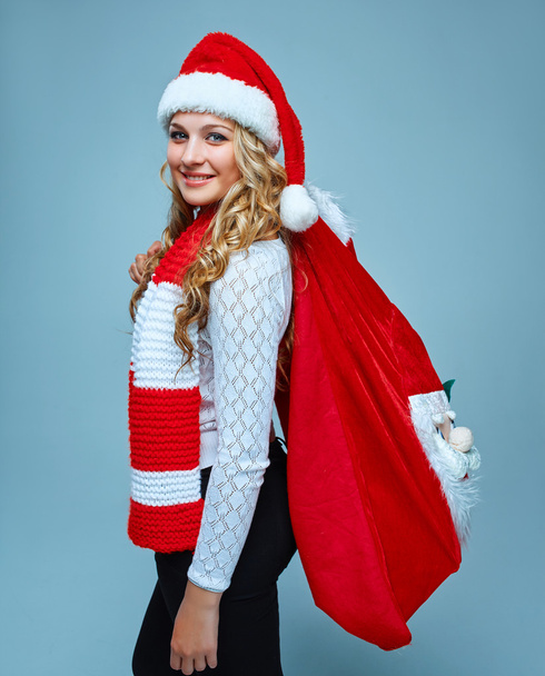 Girl dressed in santa hat holding a Christmas decoration - Фото, изображение