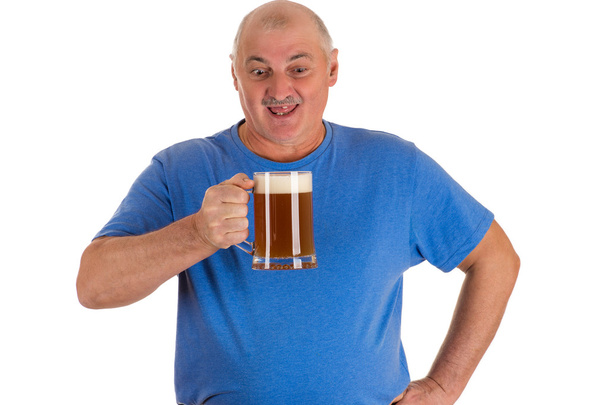 man in a blue shirt with a mug of beer in hand - Zdjęcie, obraz