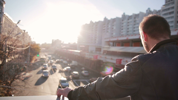 Mann sieht sich den Verkehr in der Stadt im Sonnenuntergang an - Filmmaterial, Video