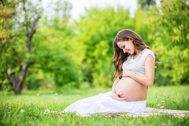mulher grávida relaxando fora no parque
 - Foto, Imagem