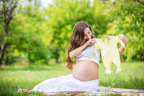 έγκυος γυναίκα, κρατώντας το βρεφικό φορμάκι - Φωτογραφία, εικόνα