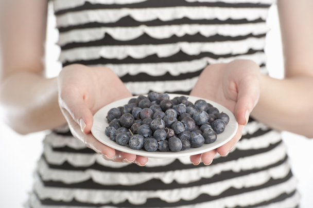 Young woman holding a plate with blueberries - Photo, Image