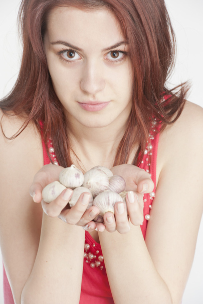 Young woman holding garlic in her hands - Fotografie, Obrázek