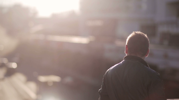 Чоловік дивиться на трафік у місті під час заходу сонця
 - Кадри, відео