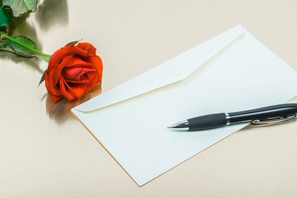 rosa vermelha com uma caneta e uma letra em branco
 - Foto, Imagem