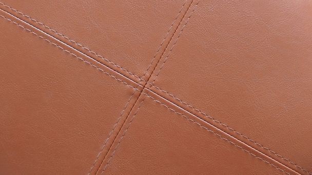 Texture of brown leather with light brown stitching in cross pattern. Useful for background design - Foto, afbeelding