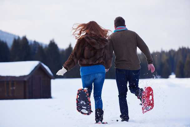 couple having fun in snow shoes - 写真・画像