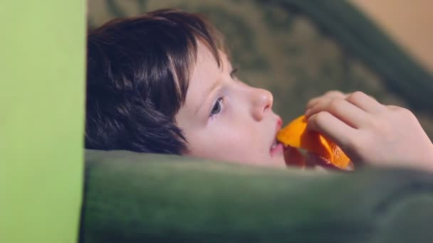 Tizenéves fiú eszik egy narancs és a héj - Felvétel, videó