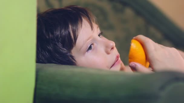 εφηβικό αγόρι τρώει ένα πορτοκάλι και η φλούδα - Πλάνα, βίντεο