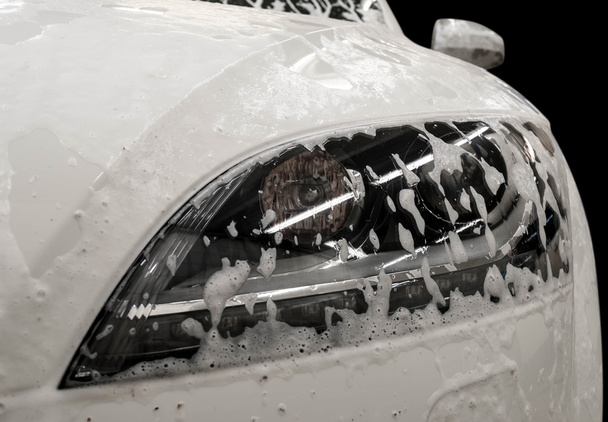 Moderní myčka aut s mýdlem. Automobilový světlomet pokrytý pěnou. - Fotografie, Obrázek