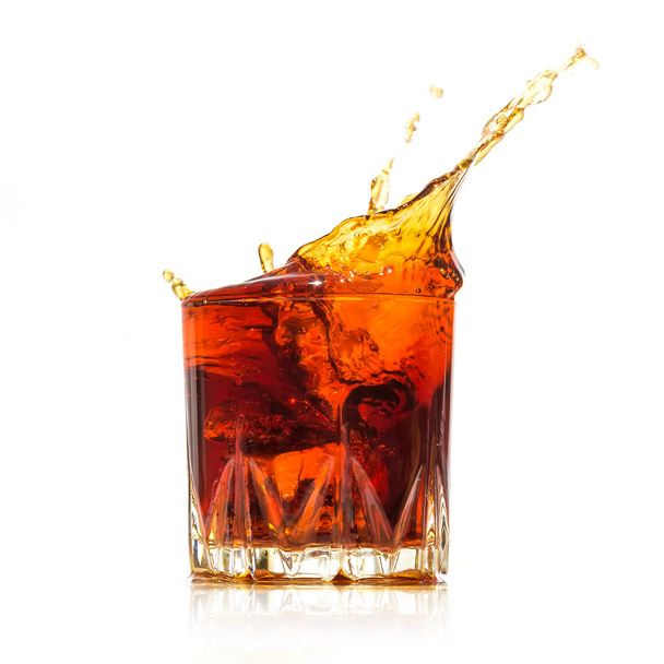 Glass with whiskey splash on white background - Valokuva, kuva