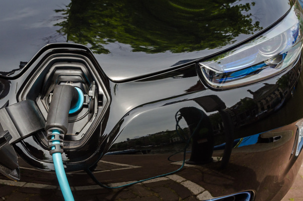 Güç kaynağı takılı modern elektrikli araba şarj ediliyor - Fotoğraf, Görsel