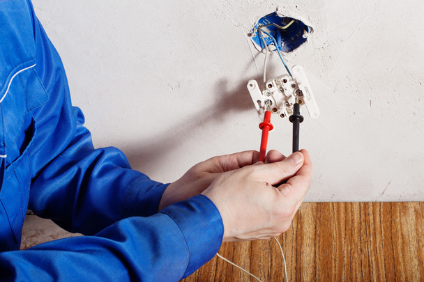 Electrician repairing socket in the house - Foto, Bild