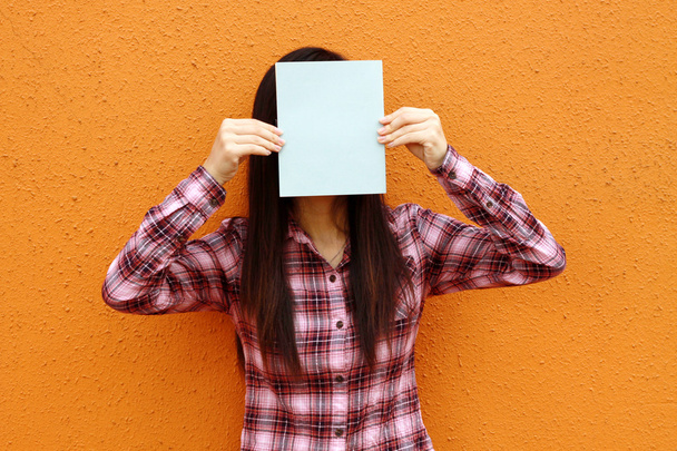 Asian woman using book to cover face - Photo, Image