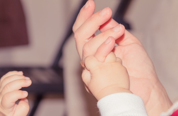 νεογέννητο μωρό χέρι κρατά ενηλίκων δάχτυλο, μητρότητας έννοια - Φωτογραφία, εικόνα