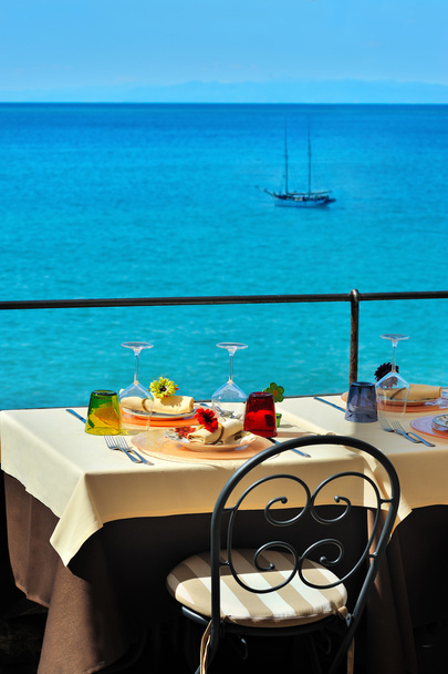 Украшенный стол на летней террасе у моря
 - Фото, изображение