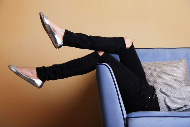 Woman legs on sofa - 写真・画像