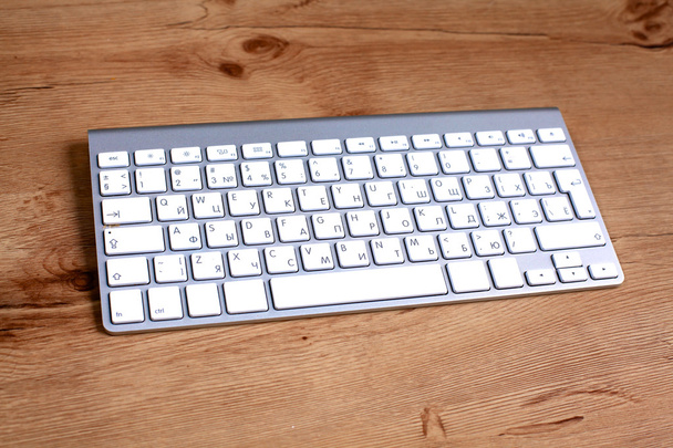 Сучасна алюмінієва комп'ютерна клавіатура на столі
 - Фото, зображення