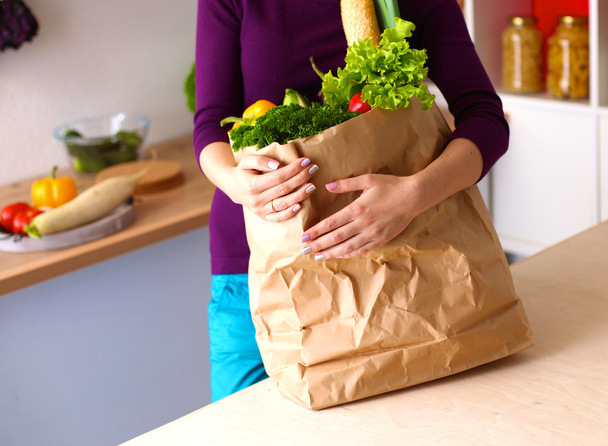 Mulher feliz positivo saudável segurando um saco de compras de papel cheio de frutas e legumes
 - Foto, Imagem