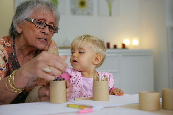 Young child coloring with grandma - Foto, imagen