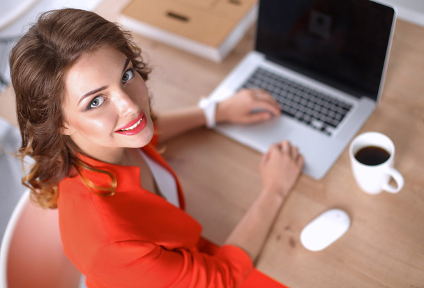 Houkutteleva nainen istuu toimistossa, työskentelee kannettavan tietokoneen kanssa - Valokuva, kuva
