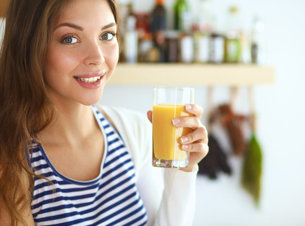 Portrait of a pretty woman holding glass with tasty juice - Fotó, kép