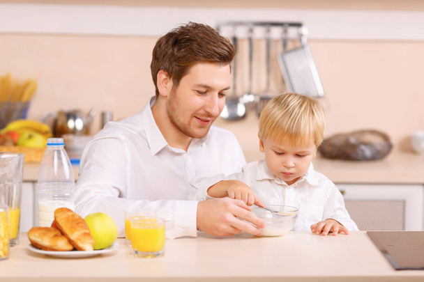 Daddy helps his son to finish a cereal. - 写真・画像