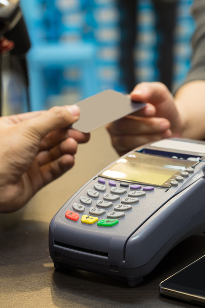 クレジット カードで支払いの手でテーブルの上のクレジット カードのマシン - 写真・画像