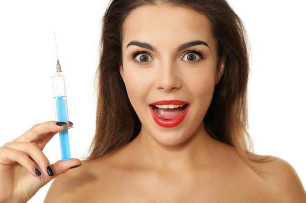 Young emotional woman holding syringe, isolated on white - 写真・画像