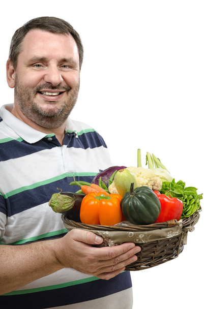 Smiling retailer with a basket of vegetables - Foto, afbeelding