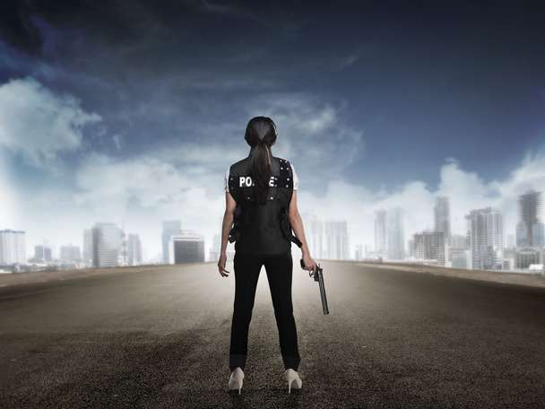 Police woman standing on the empty street - Foto, imagen