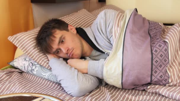 Giovane uomo sdraiato, guardando e pensando a letto
 - Filmati, video