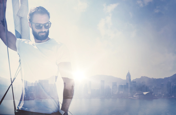 Duble exposure of young bearded man standing on a yacht and looking at the horizon. Visual effects - Foto, afbeelding