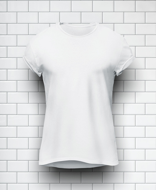 White tshirt isolated on the wall of bricks background - Fotoğraf, Görsel