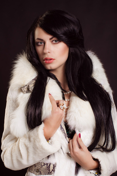Hermosa chica con el pelo oscuro en un abrigo de piel blanca
 - Foto, imagen