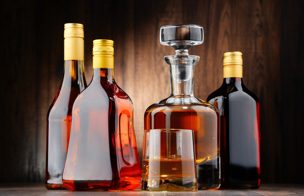Flaschen verschiedener alkoholischer Getränke und ein Glas Whisky - Foto, Bild