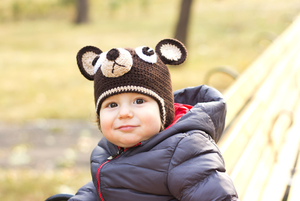 Joyeux enfant dans une casquette en forme d'ours en peluche. Happy Child en promenade. L'enfant est dans l'air à l'automne
 - Photo, image
