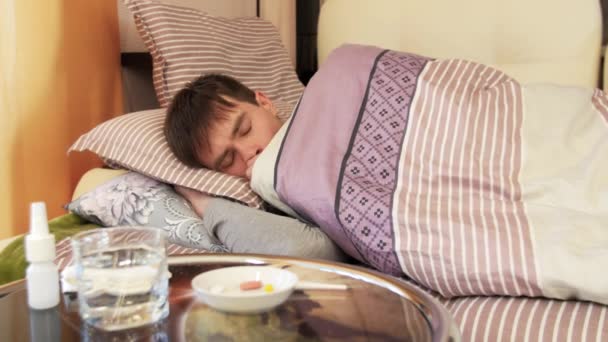 Άρρωστος άνθρωπος ξαπλωμένος στο κρεβάτι και βήχα - Πλάνα, βίντεο