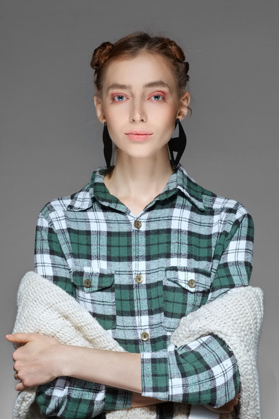 young lady posing with crossed hands in warm cell shirt and sweater - 写真・画像