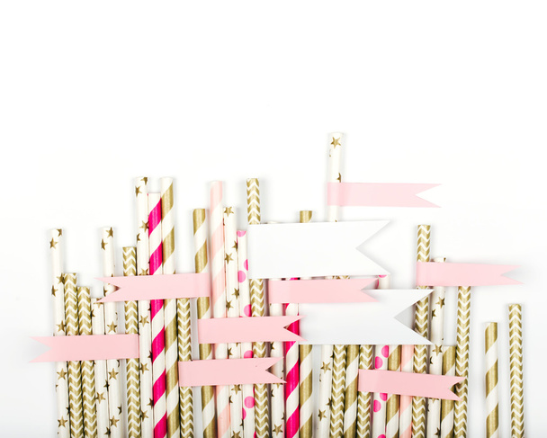 Striped mixed gold and pink paper straws with a sticker on white background - Fotografie, Obrázek