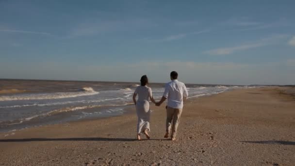 Jovem casal branco correr ao longo da praia
 - Filmagem, Vídeo
