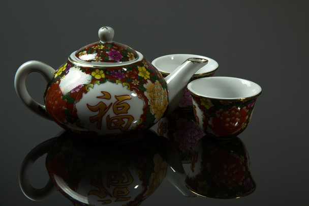 Китайський глечика і дві чашки з дзеркального відображенням на isolateg гр - Фото, зображення