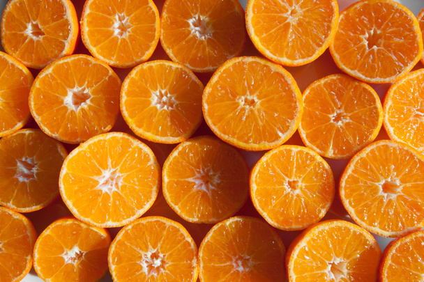 Orangengeschnittene Mandarinen auf einem Tisch als Hintergrund - Foto, Bild