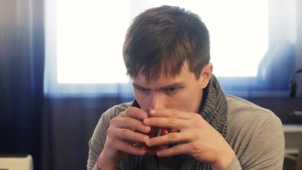 Chory człowiek picia gorącej herbaty, trzymając kubek. Ujęcie statyczne - Materiał filmowy, wideo