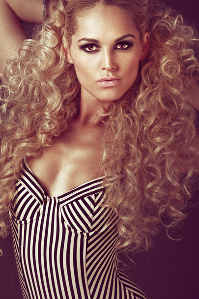Young girl with long curly blond hair. - Фото, изображение