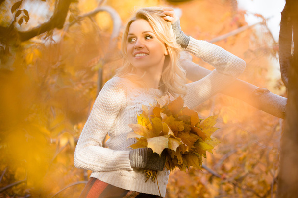 Blond woman with bouquet from maple leaves - Фото, зображення