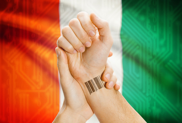 Barcode ID number on wrist and national flag on background - Ivory Coast - Fotoğraf, Görsel