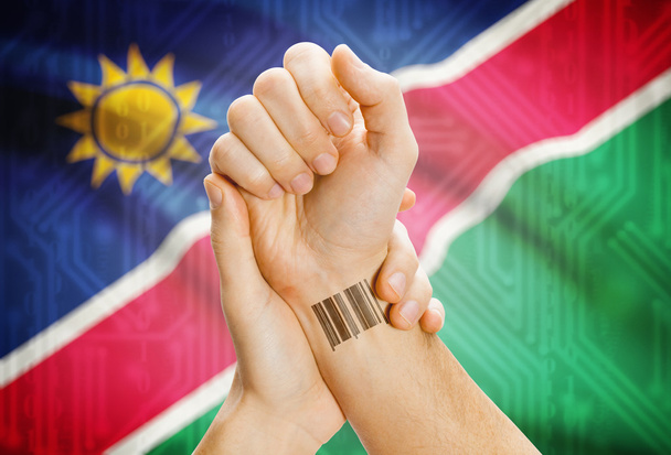 Barcode ID number on wrist and national flag on background - Namibia - Foto, Imagen