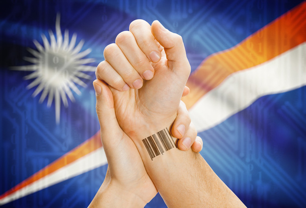 Barcode ID number on wrist and national flag on background - Marshall Islands - Foto, Imagen